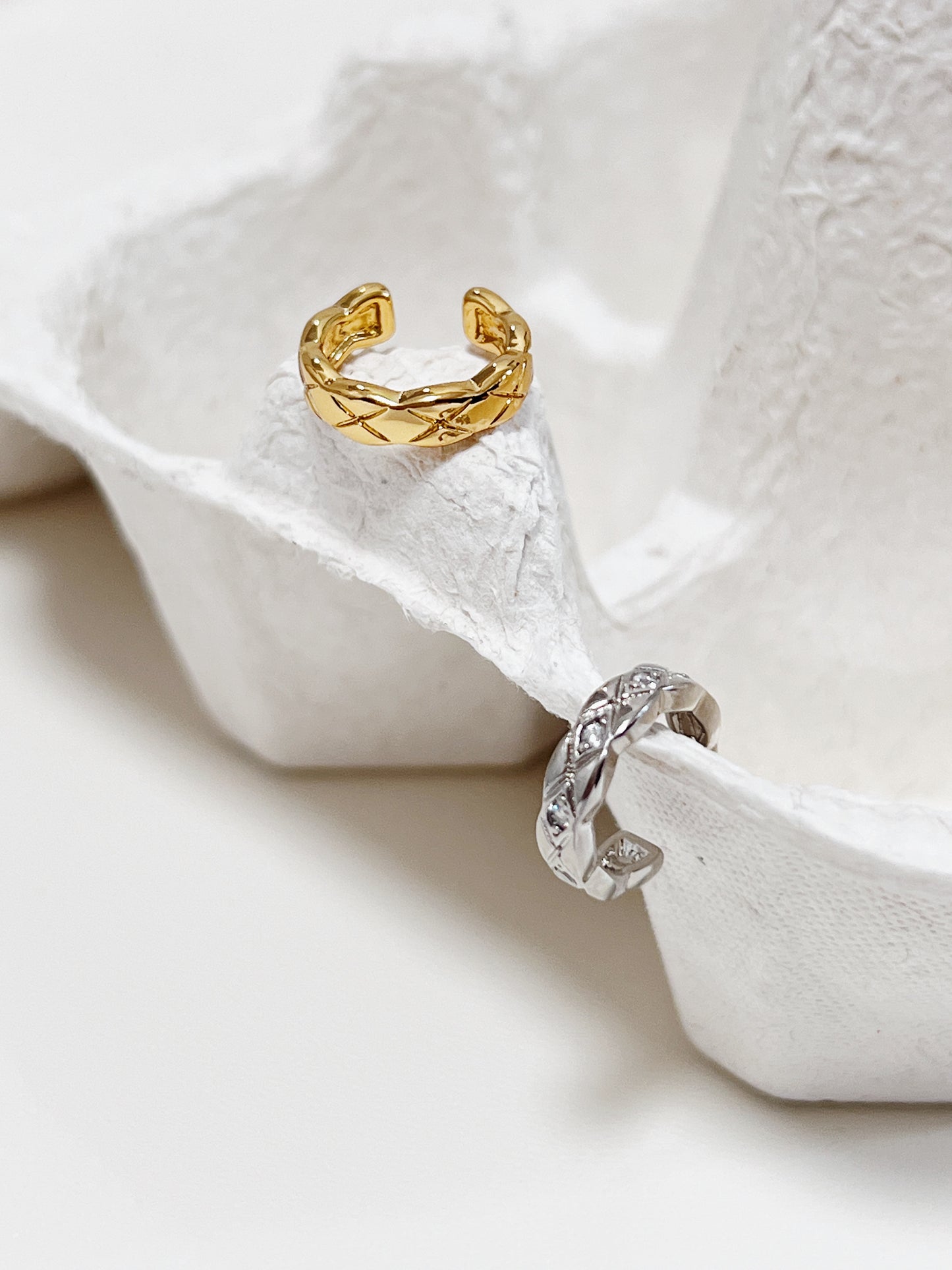 Pair of Louie ear cuffs in gold and silver showing high-mirror finish.