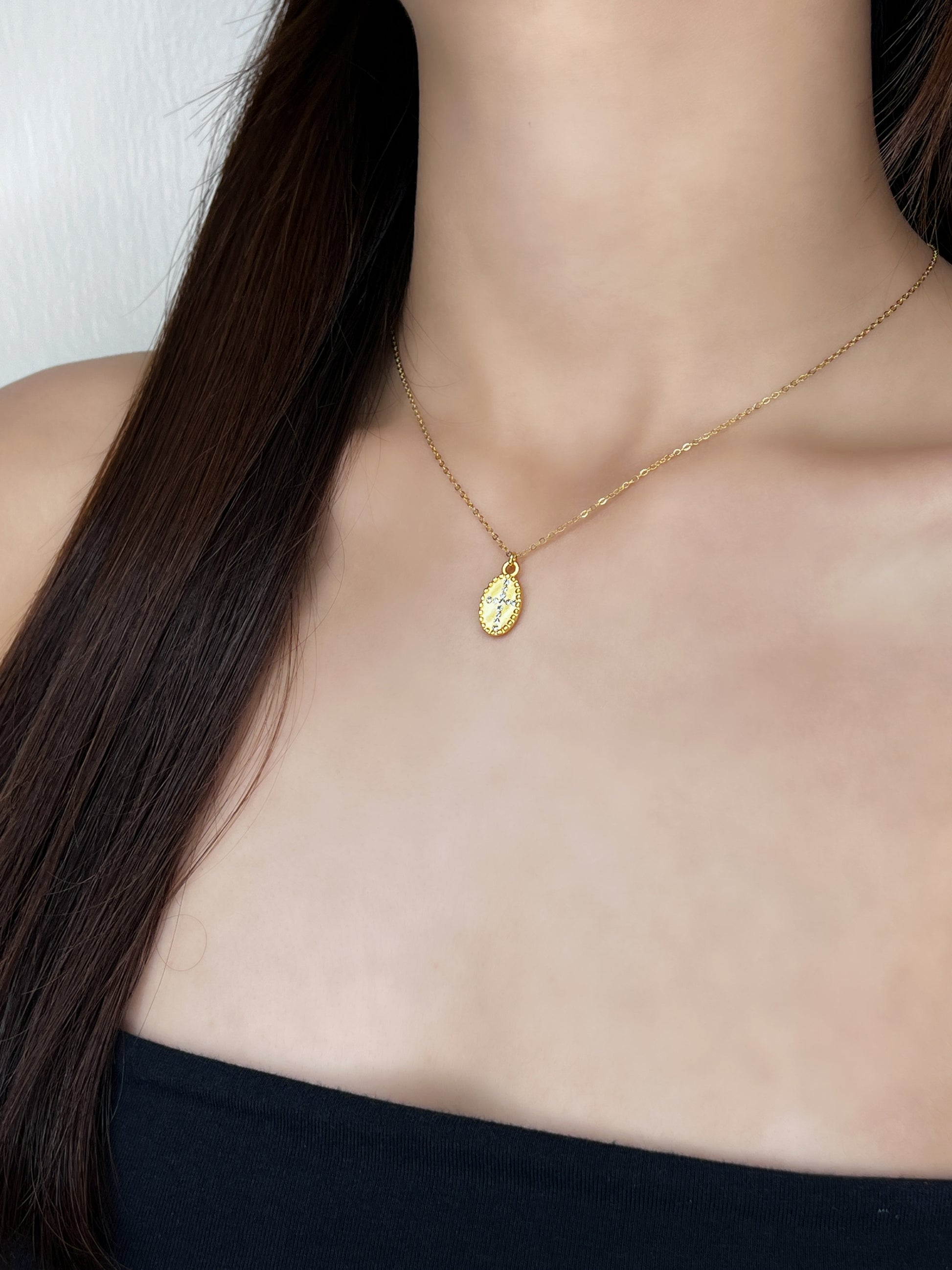 A studio presentation of the Gianna cross necklace styled on a female model to highlight its luxury and minimal aesthetic