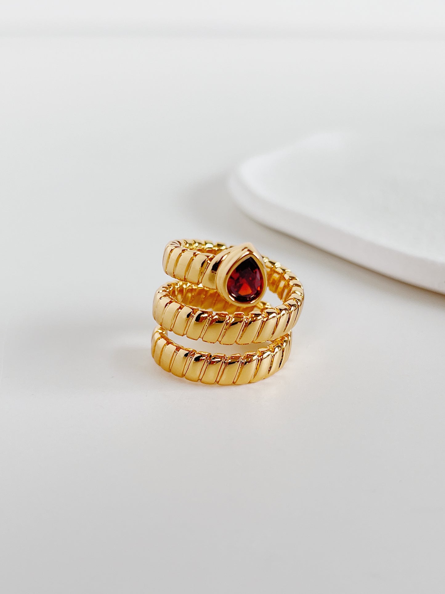 Soft mirror shine ruby like gemstone ring by Aurous Atelier on white surface