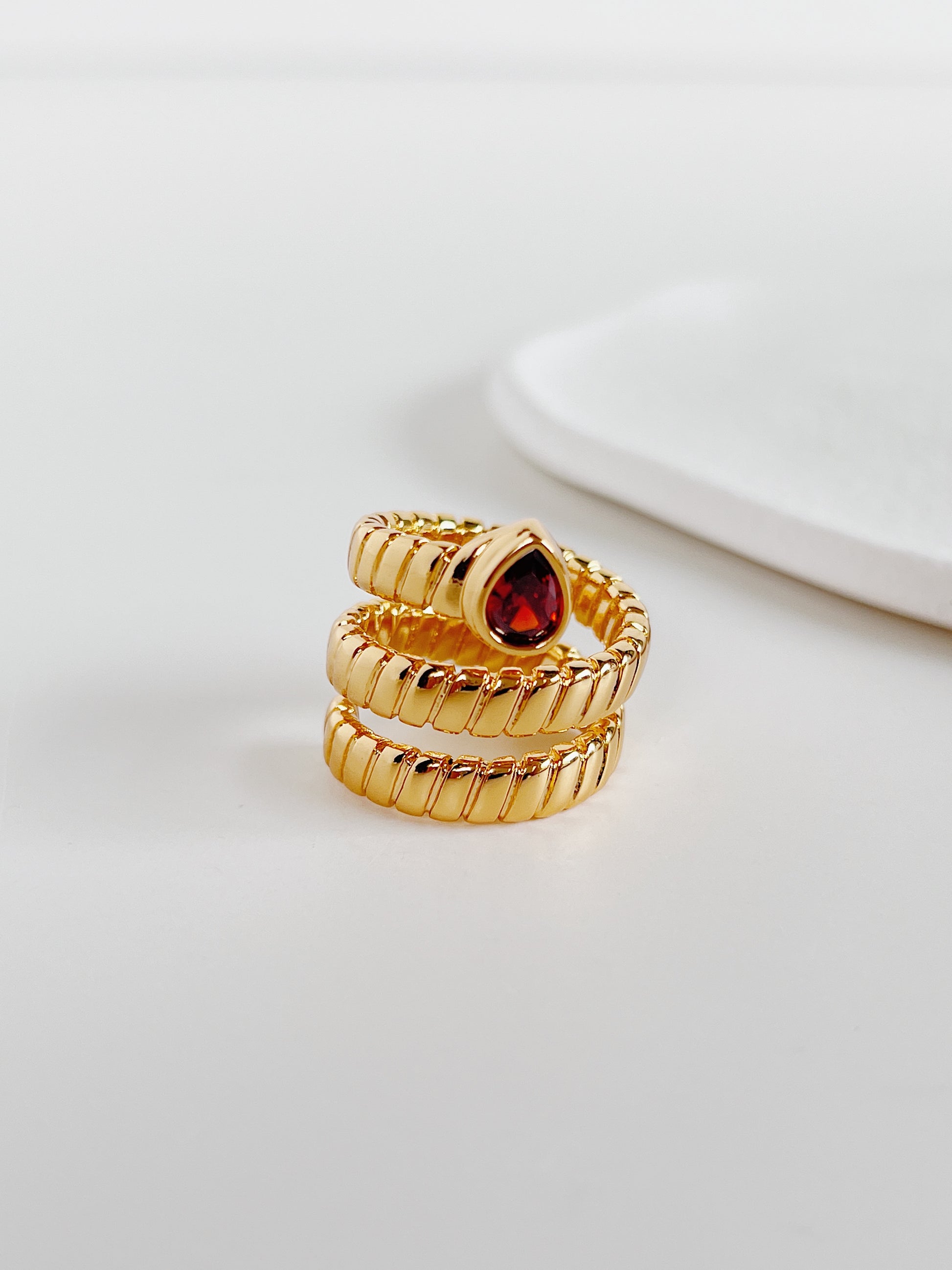 Soft mirror shine ruby like gemstone ring by Aurous Atelier on white surface
