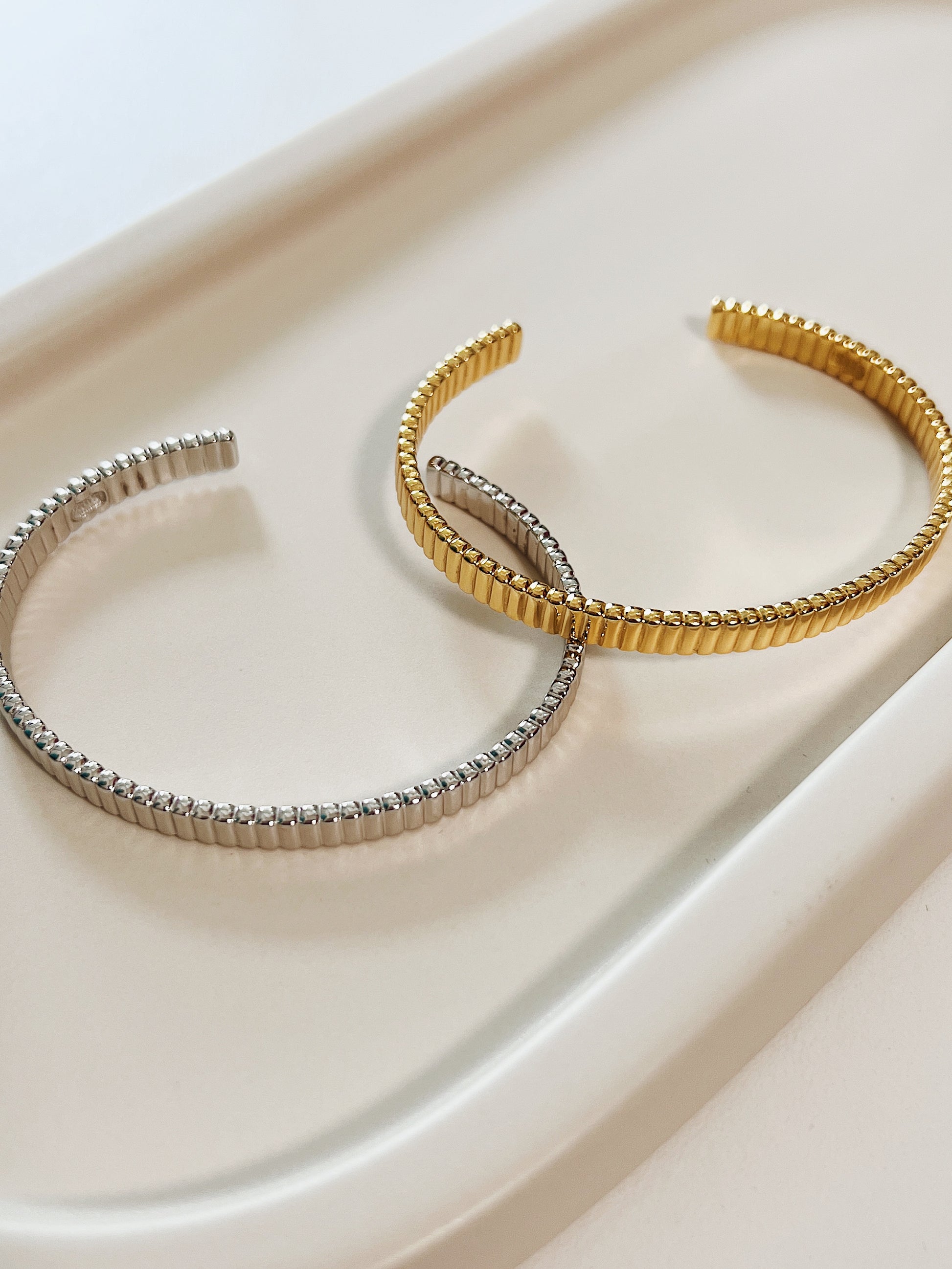 Complete studio layout of the Vede gold and silver texturized cuffs emphasizing their premium finish and uniform architectural grooves.