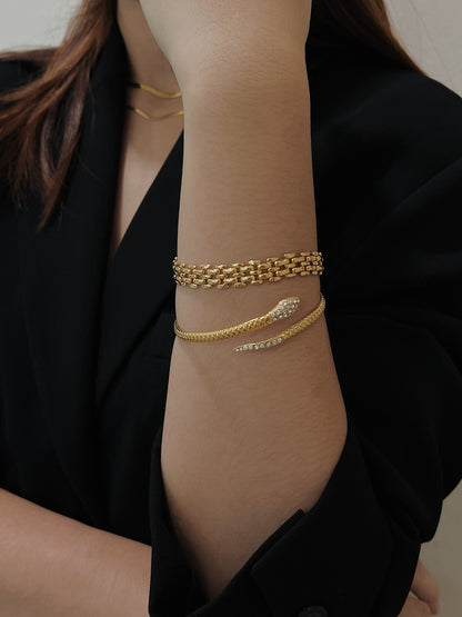 Model arm angled to demonstrate the effortless stacking versatility of the gold Isa Serpent Bangle.