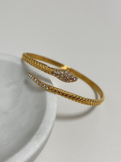 Close-up detail of the 5A cubic zirconia pavé head on the gold Isa Serpent Bangle.