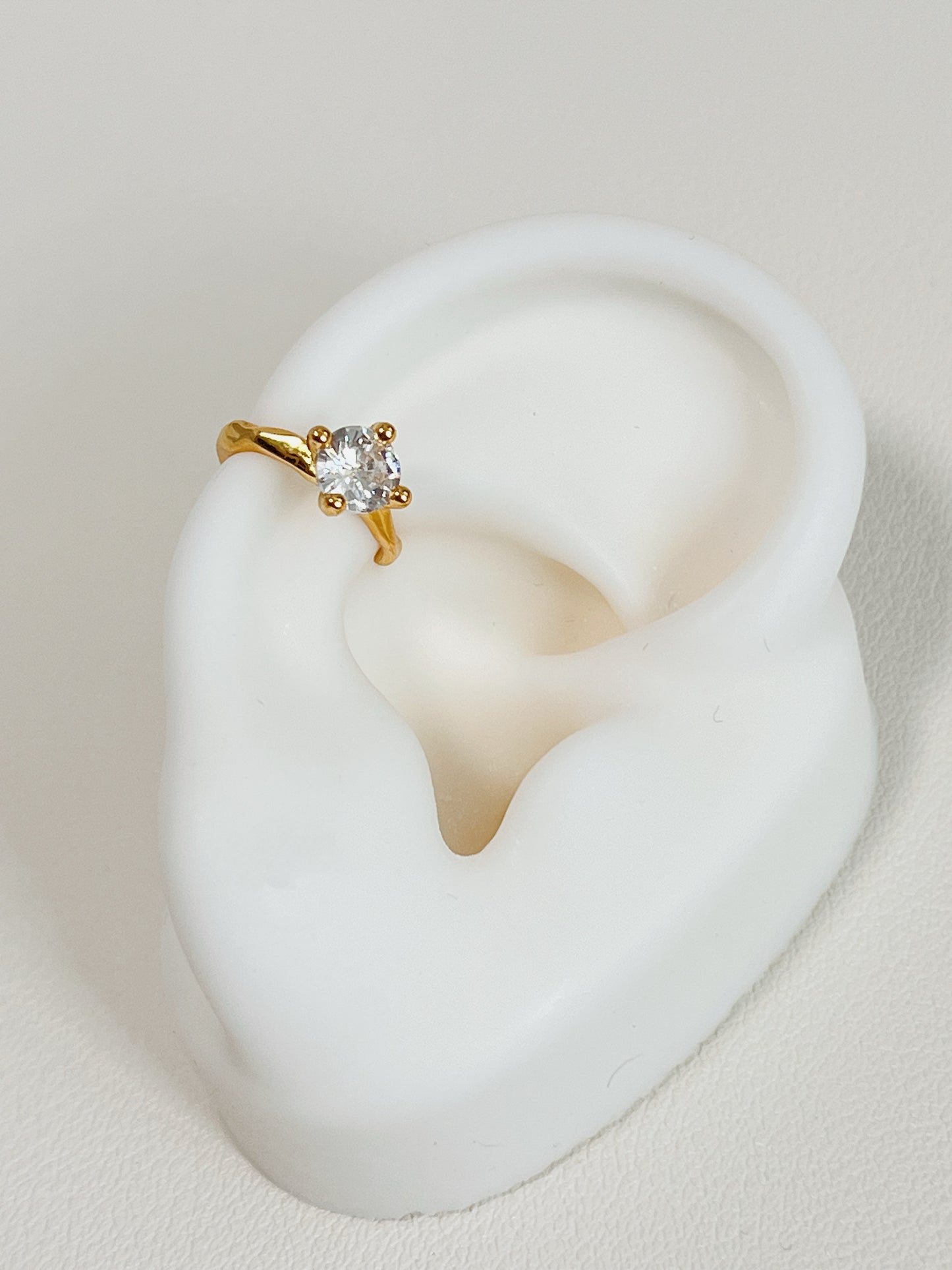 Detailed fit of non-pierced gold cuff on cartilage.