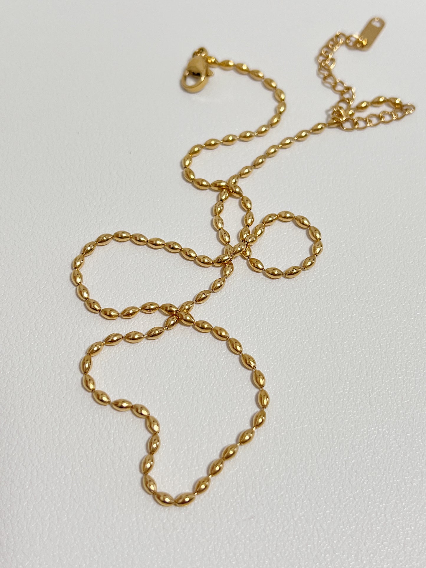 Aurous Atelier minimal catalog display illustrating a high end gold capsule ball chain layout