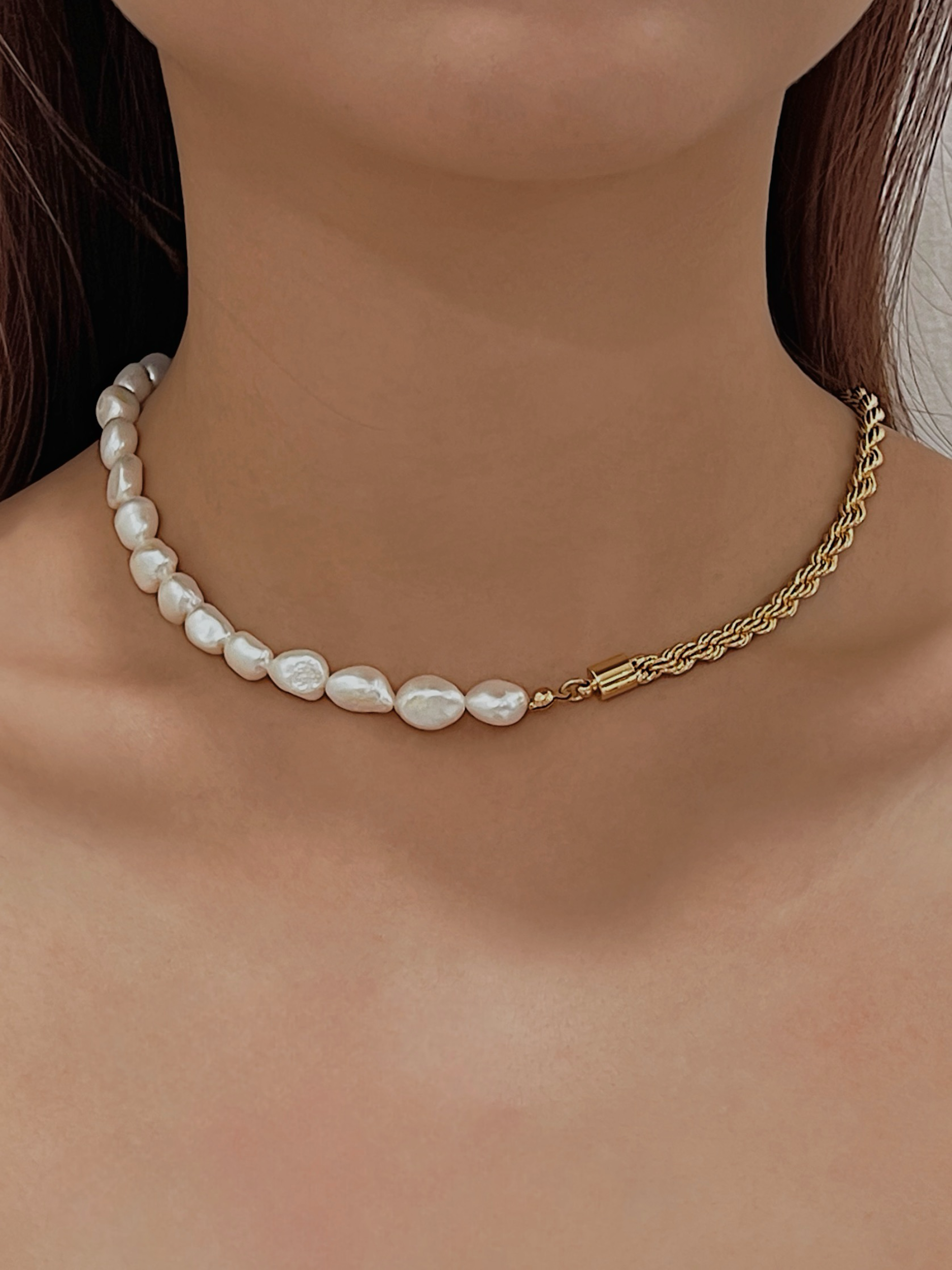 Woman skin close up showcasing modern split strand pearl jewelry resting on bare neckline