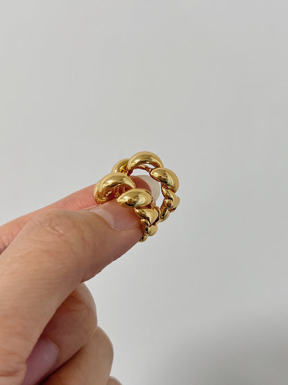 Close up of woman's finger holding a pair of stunning Gold Rope Earrings made of 18k gold plated