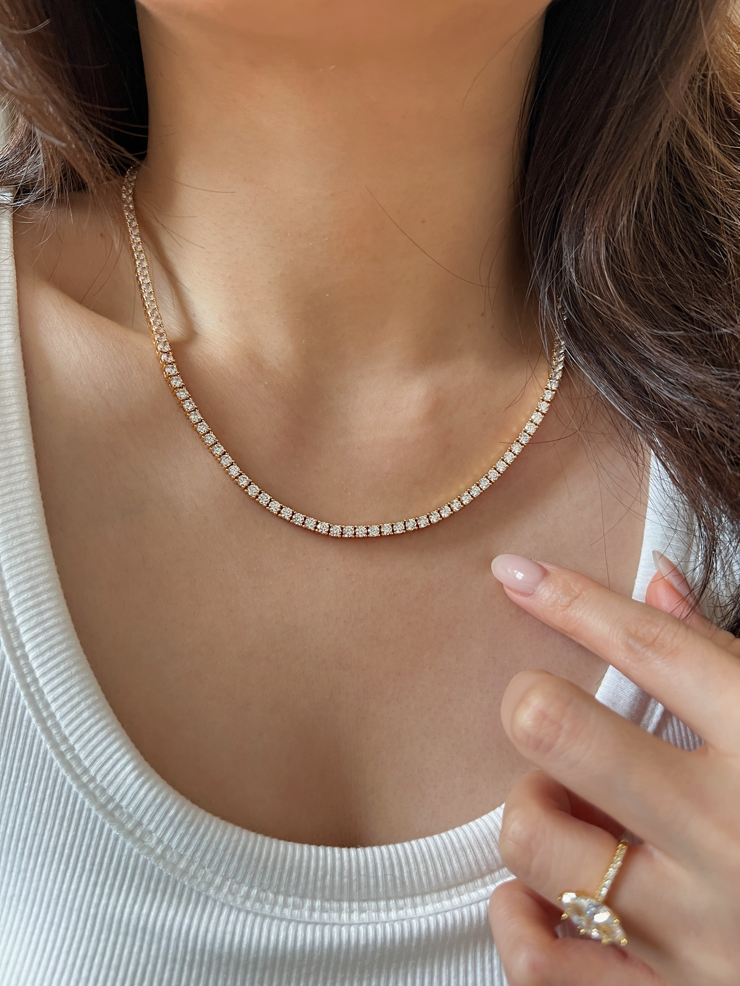 Model collarbone view styling elegant 18k gold PVD tennis necklace strand on bare skin