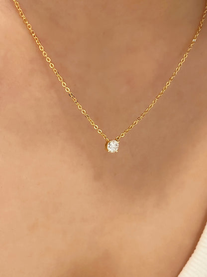 Close up view of model wearing four prong basket setting of Cala 14k gold plated moissanite solitaire necklace