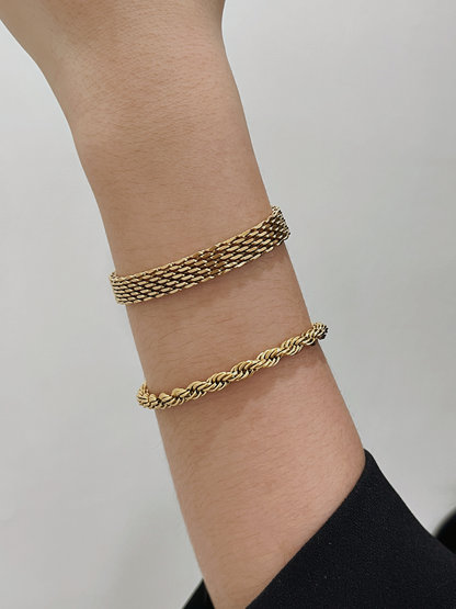 Close-up shot of the Cali 5mm gold rope bracelet sitting flush on a wrist alongside a flat gold mesh bracelet.