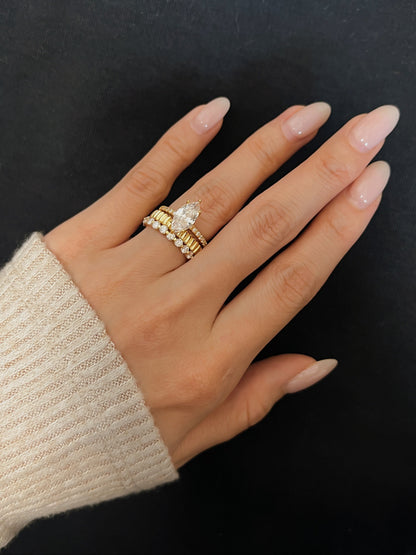 On model perspective of the Callie moissanite eternity ring layered in an elite gold ring stack featuring a kinn marquise diamond alternative solitaire