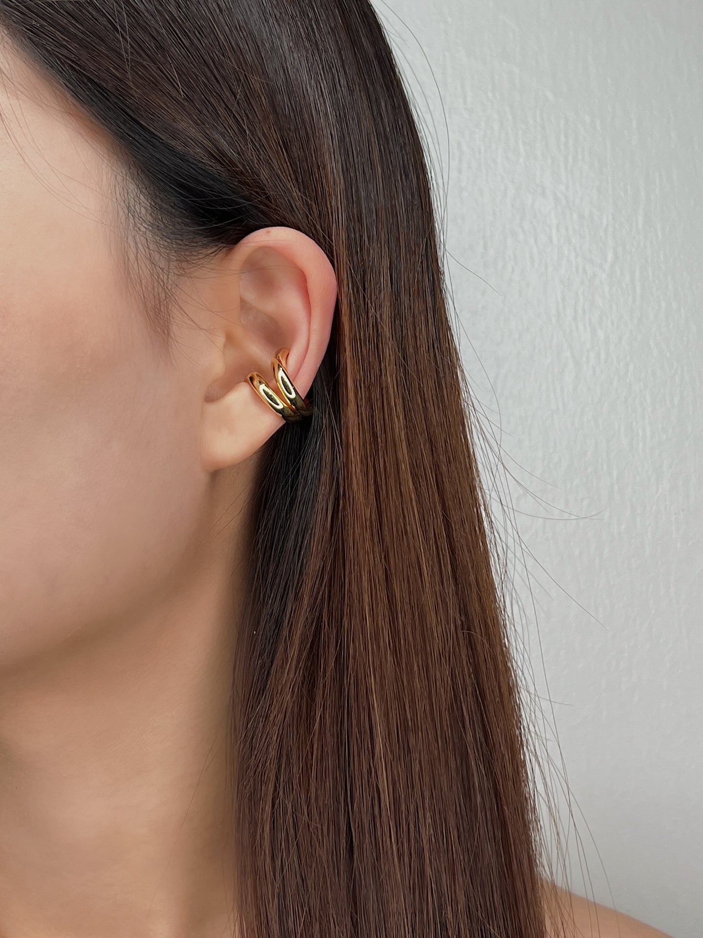 Model styling Tobi cuffs with slicked-back hair.