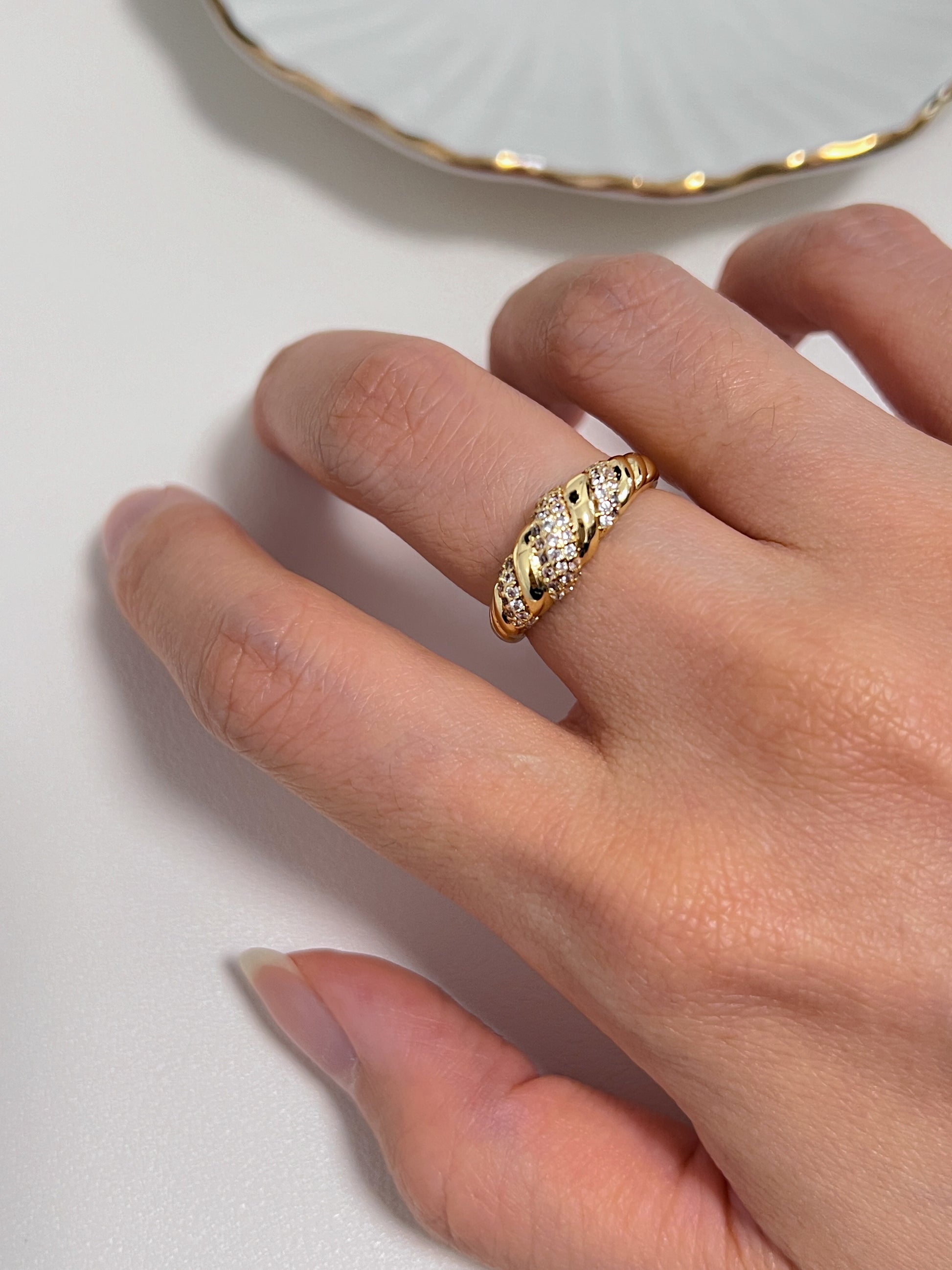 Close-up of model's hand featuring the bold Claudia ring on the middle finger.