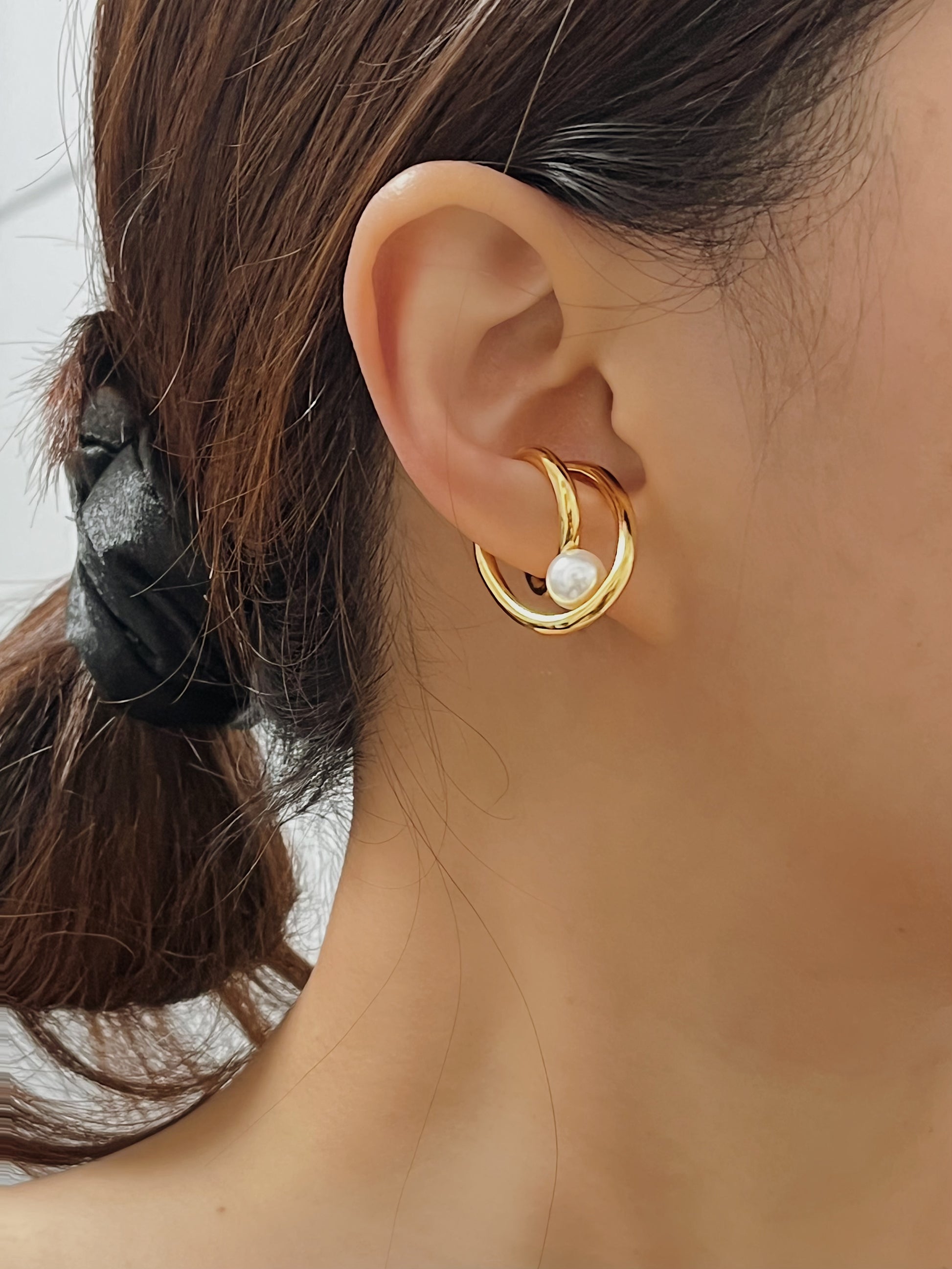 High-end product on model imagery of the Karolina non-pierced gold pearl cuff earring for an elegant, understated fashion look.