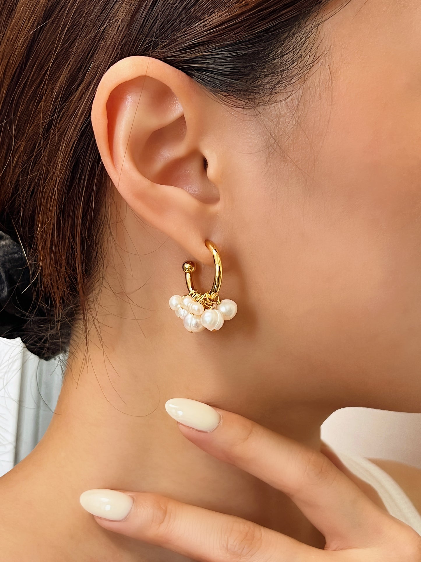 Close-up ear curation styling demonstrating how the Freya 18K gold cluster pearl hoops drape elegantly against the lobe for everyday luxury.