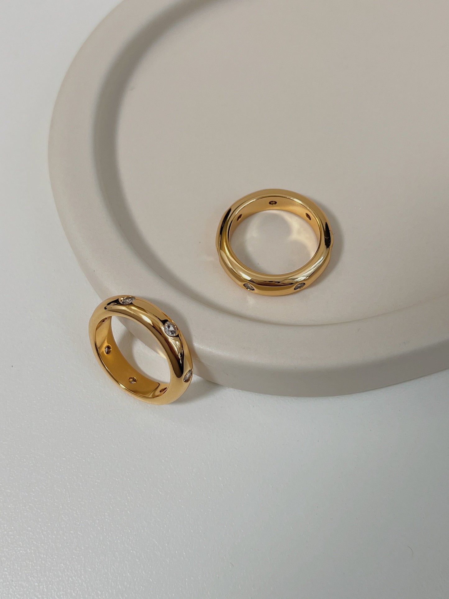 Close up of high polish gold dome ring with sparkling CZ accents