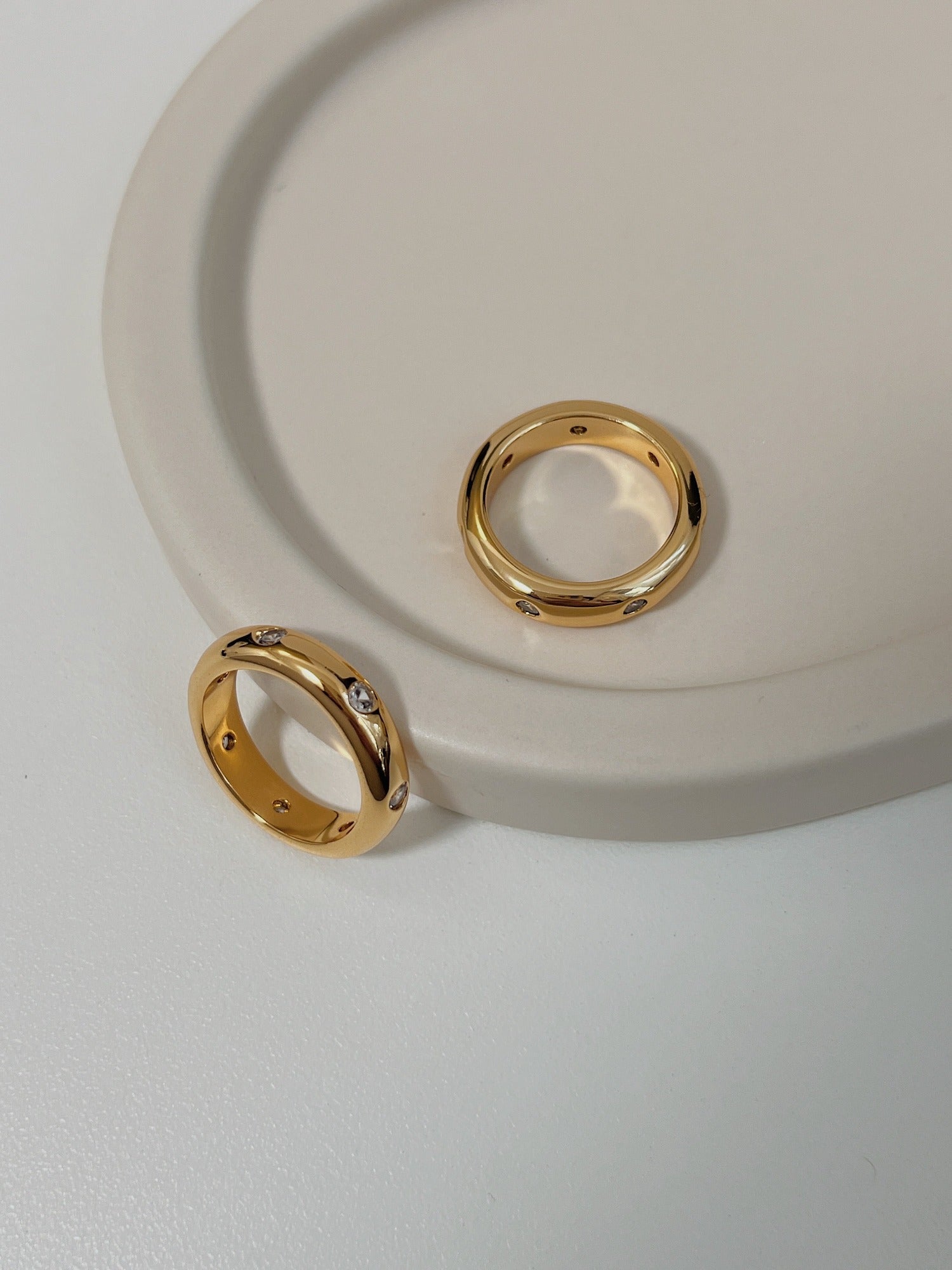 Close up of high polish gold dome ring with sparkling CZ accents