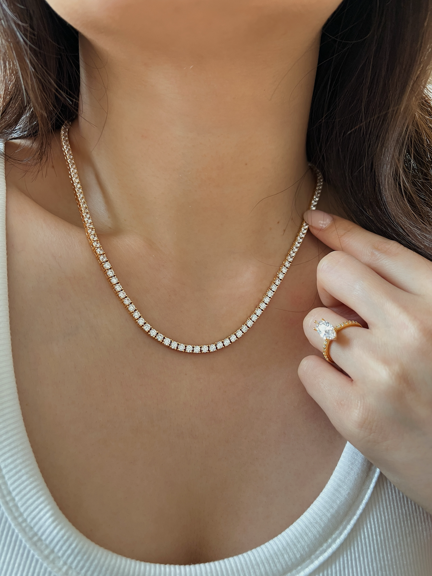 Close up view of a woman with a long hair look wearing gold jewellery with diamond accents