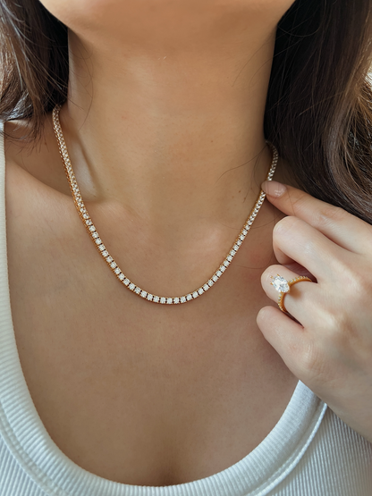 Close up view of a woman with a long hair look wearing gold jewellery with diamond accents