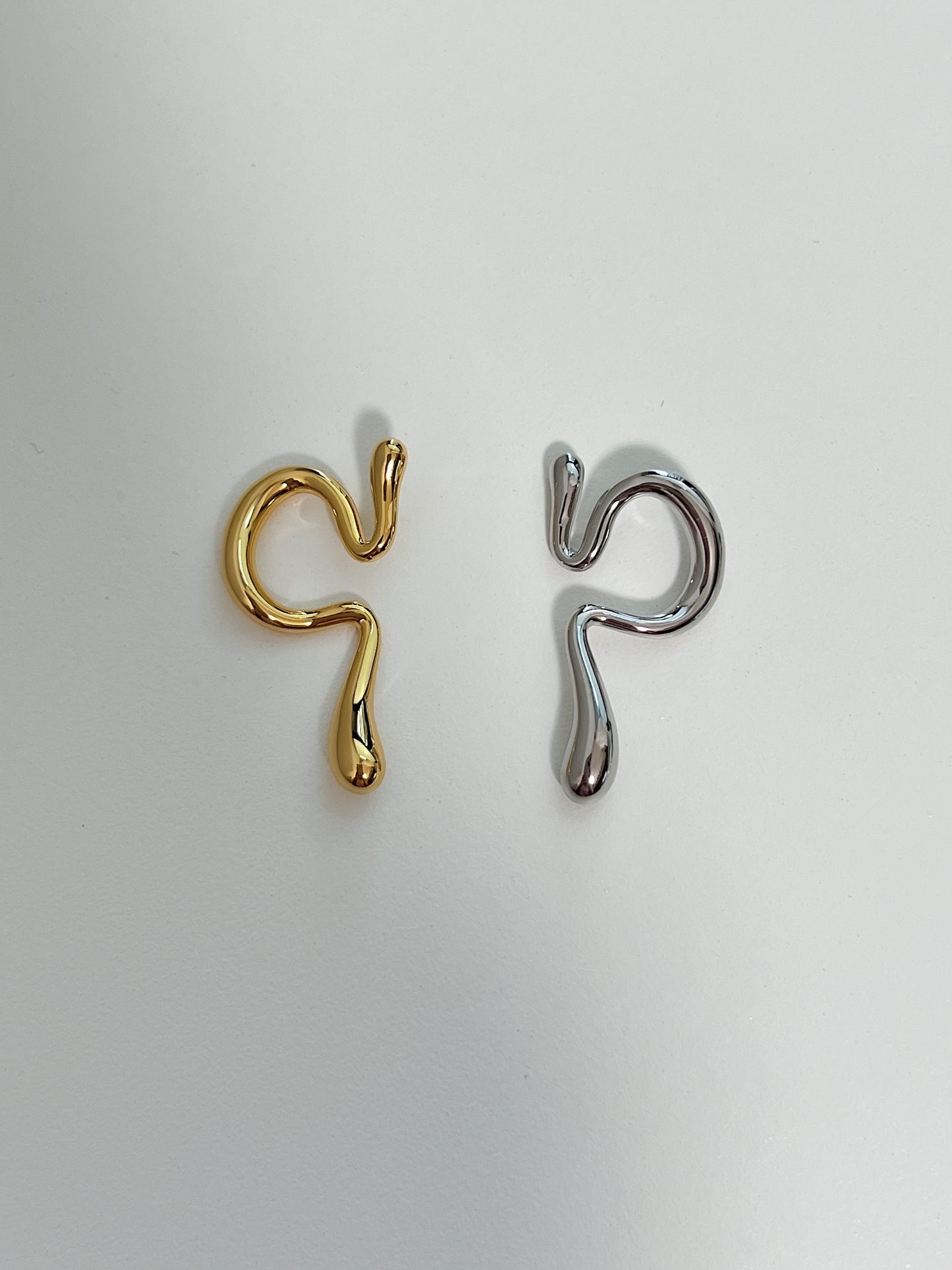 Detail view of the high-shine gold and silver finish on a sculptural abstract cuff.