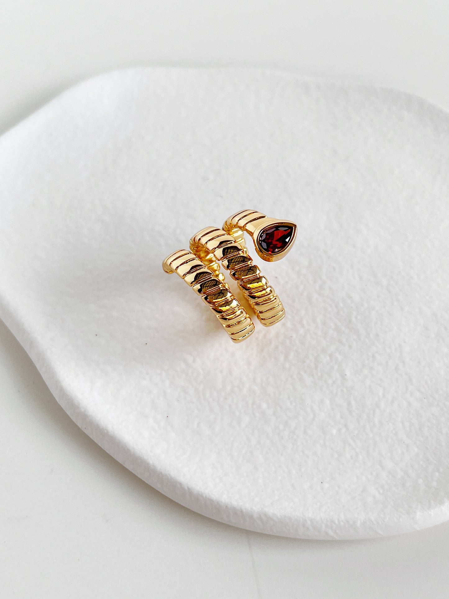 Top view of the coiled snake band ring with a red cubic zirconia stone