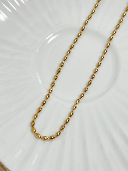 Close up shot of the elongated oval beads on the 18k gold plated stainless steel choker