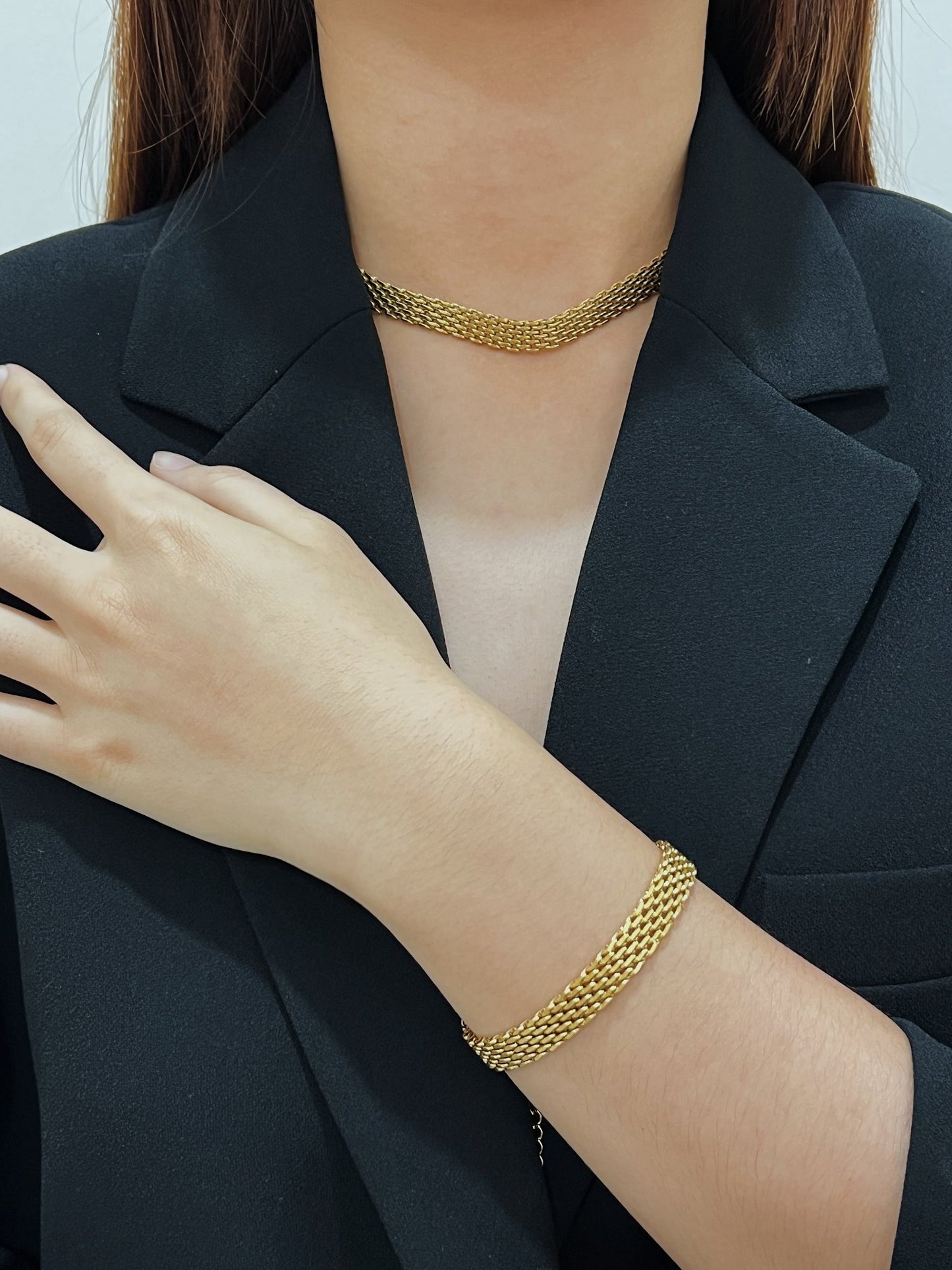 Sophisticated lifestyle display illustrating how a wide gold collar anchors an understated luxury wardrobe