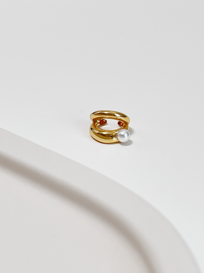 Close-up of gold Dior Pearl Double Ear Cuff showing the parallel bands and luminous pearl.