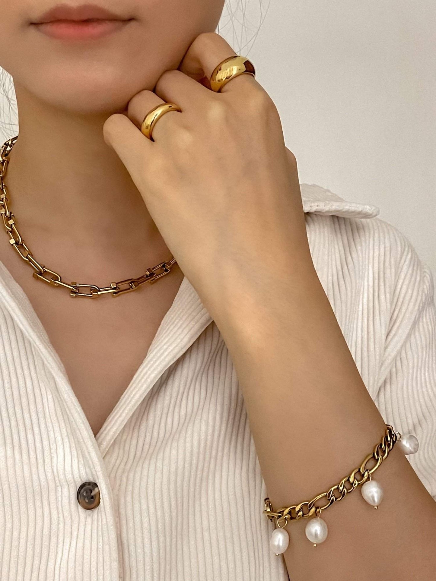 Editorial model shot showcasing gold jewellery featuring gold dome ring, chunky necklace, and bracelet