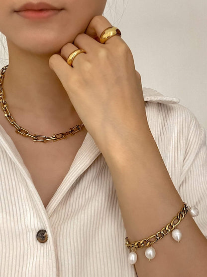 Editorial model shot showcasing gold jewellery featuring gold dome ring, chunky necklace, and bracelet