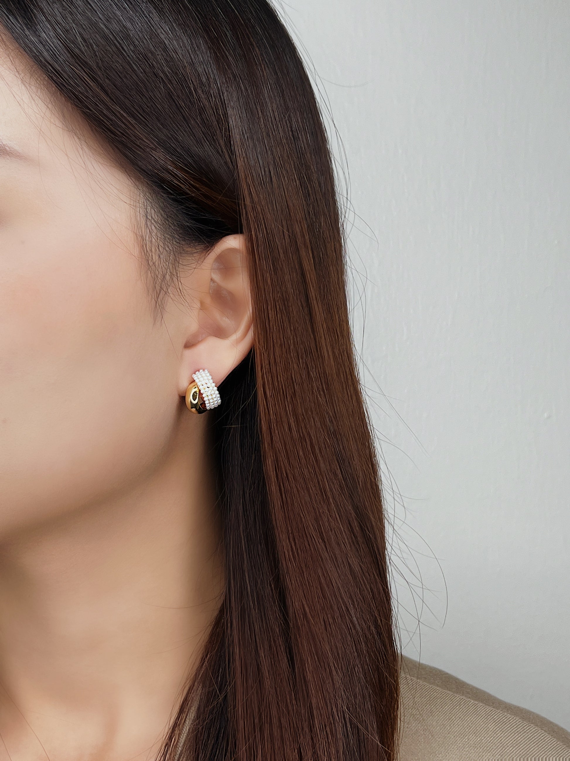 Woman ear edit displaying dimensional look of stacked double hoop illusion studs