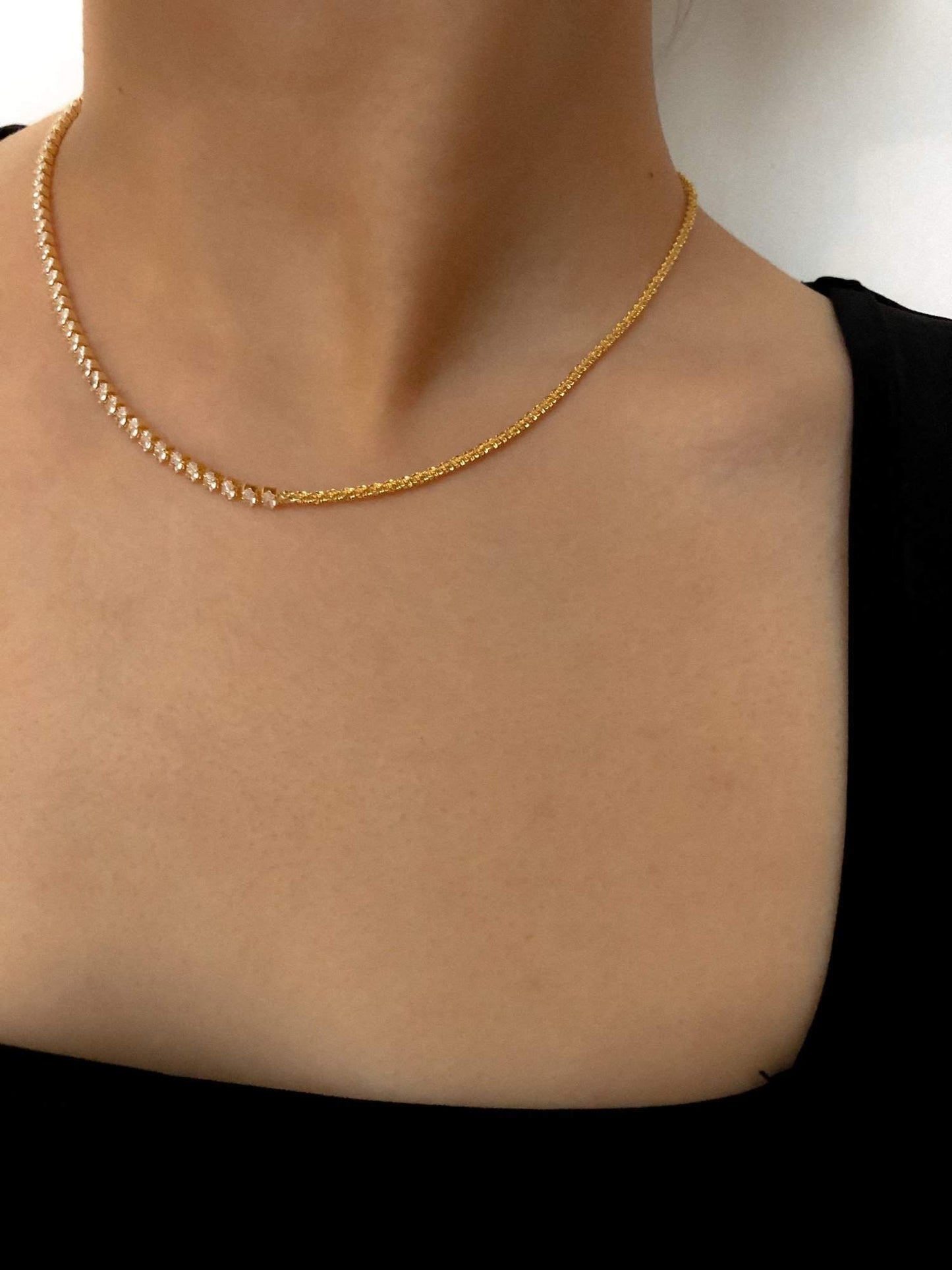 Woman neckline displaying the modern look of a singular half chain half crystal strand close up