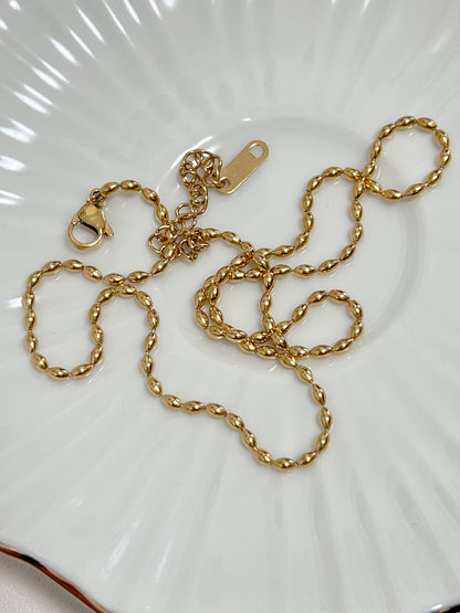 Presentation of the Livia chain displaying its supple link pattern on a white fluted background