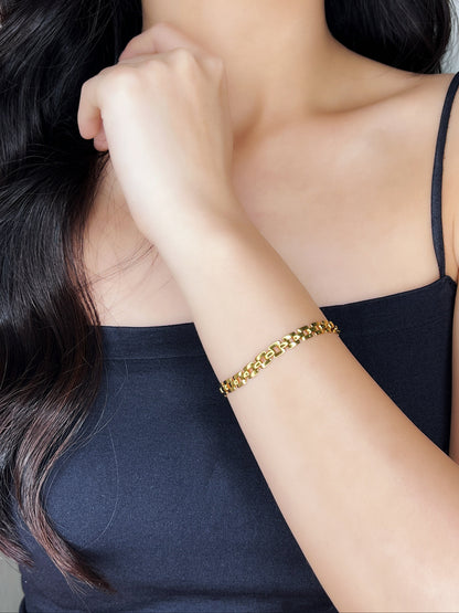 Mid-shot of a model showcasing the gold Evie link chain against a black top.