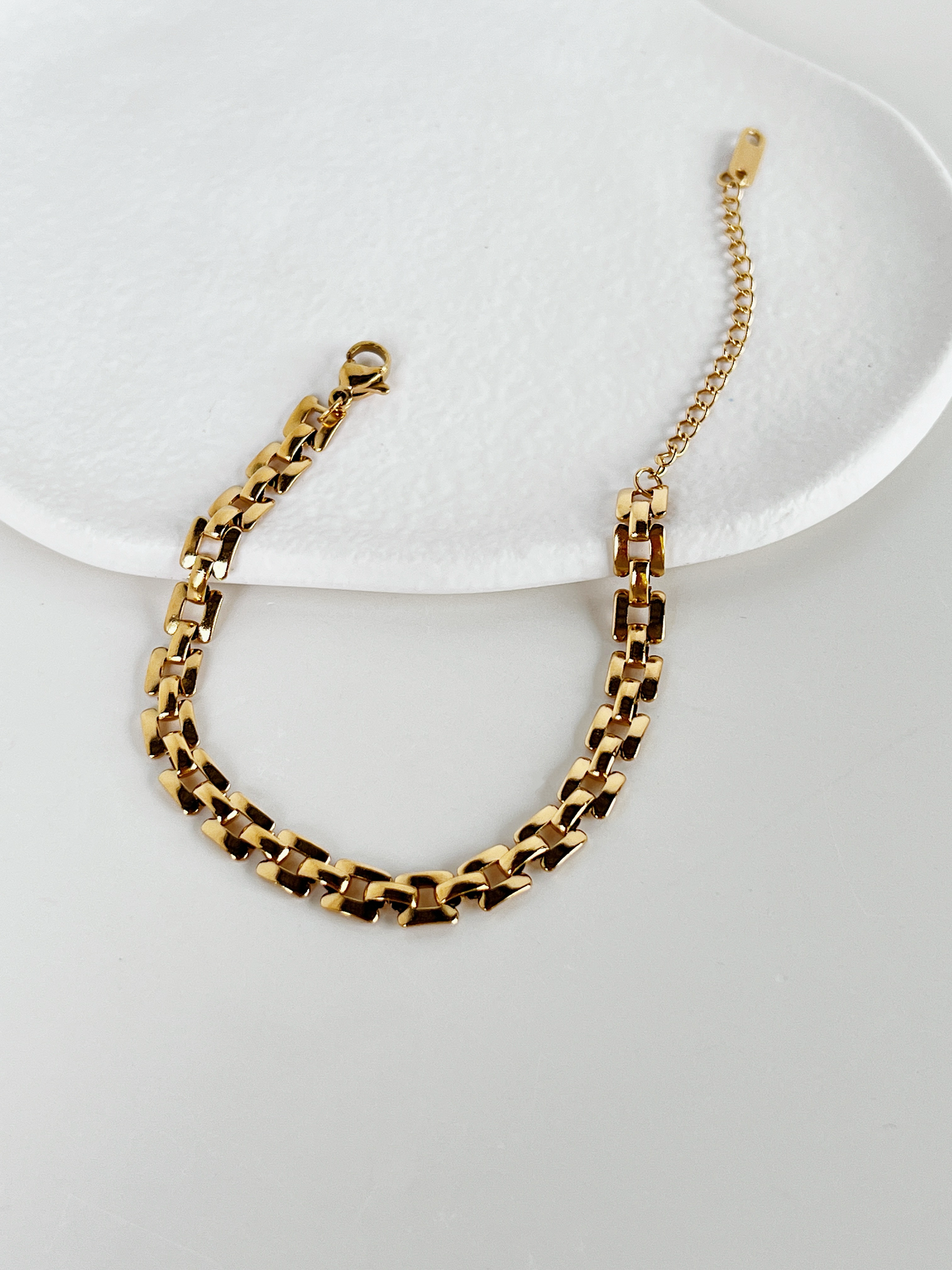Low-angle product shot showing the thin, low-profile height of the Evie watchband links resting flat.