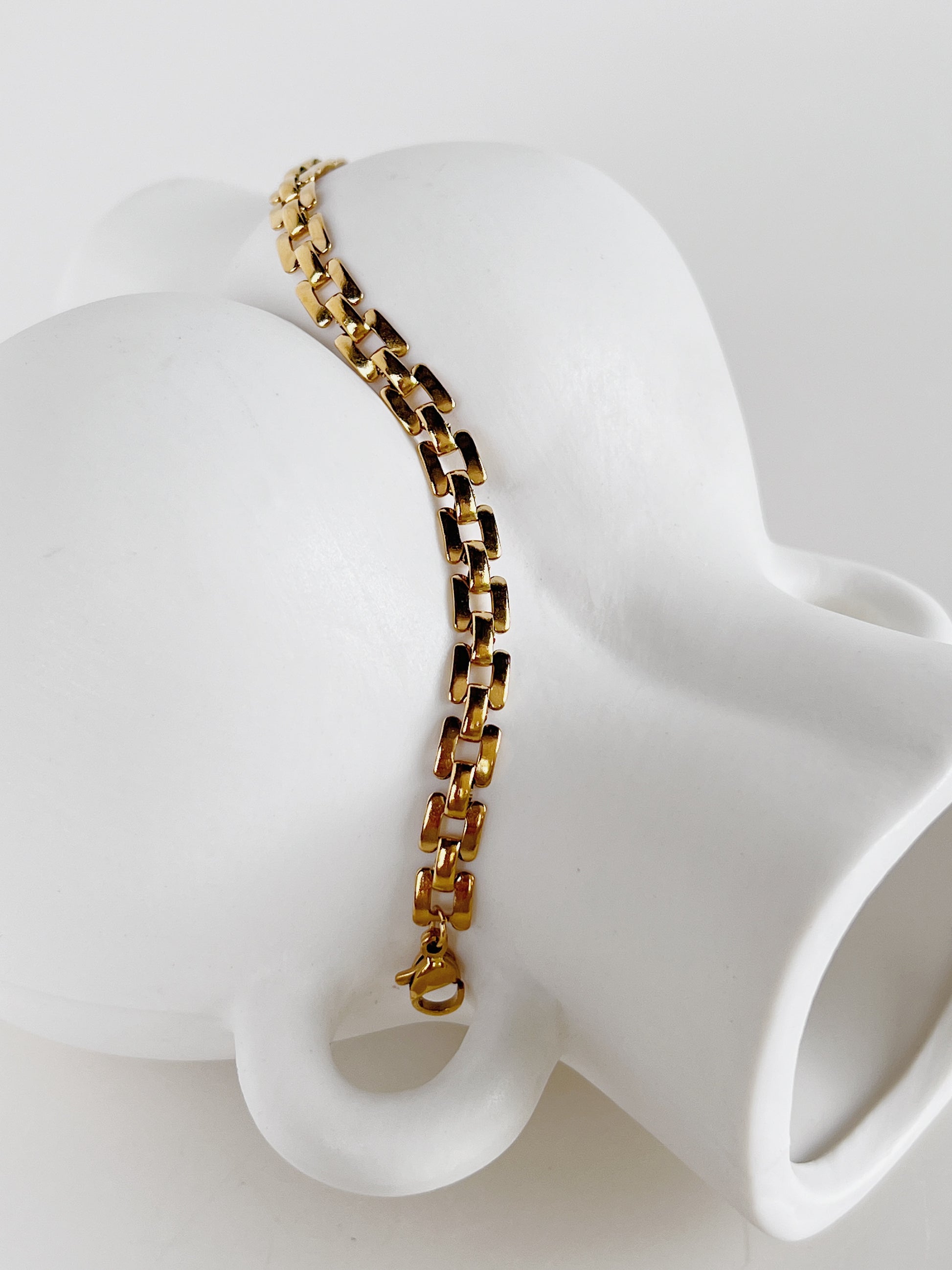 Bright studio shot capturing light glinting off the polished surface of the Evie 18K gold PVD chain bracelet.