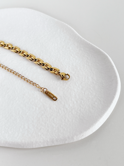 Minimalist studio shot focusing on the slender lobster claw closure and adjustable tail chain of the Evie stainless steel bracelet.