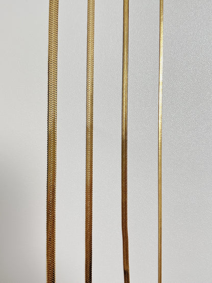 Thick and thin flat snake chain necklaces highlighting the flexible unyielding stainless steel core architecture