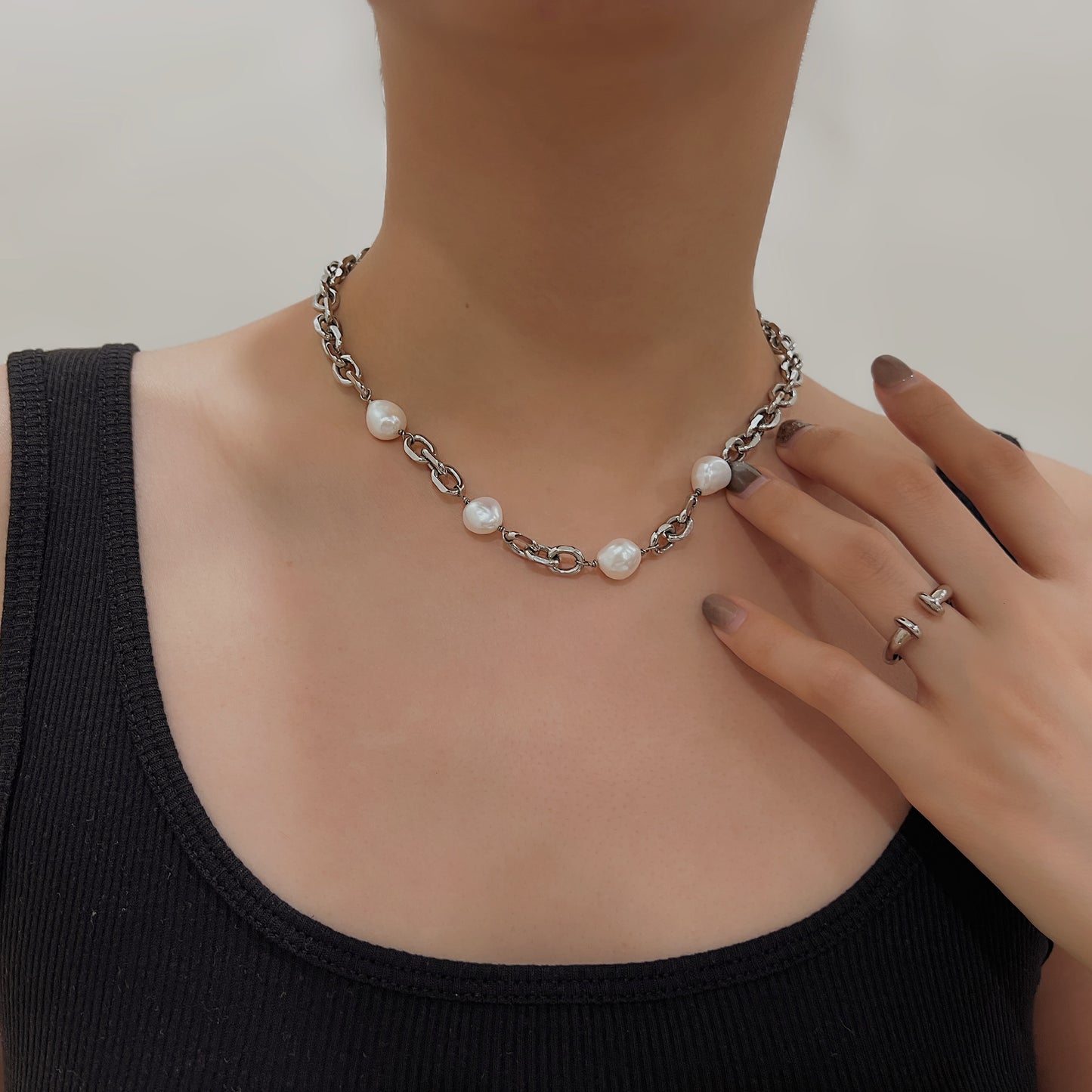 Close up of a woman wearing high shine silver link jewelry with casual clothing