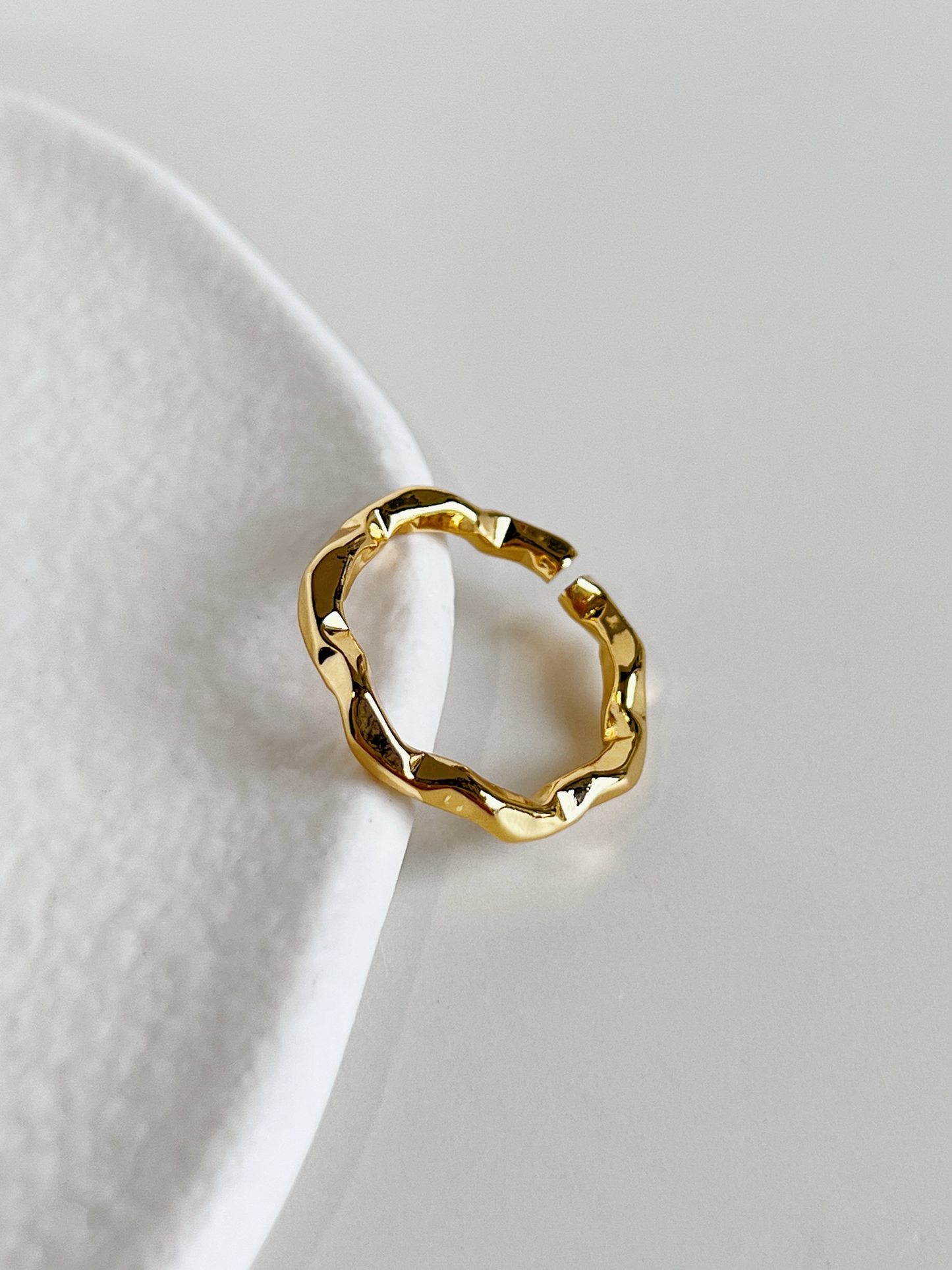 Close-up view of the soft organic wave curves on the dainty gold band