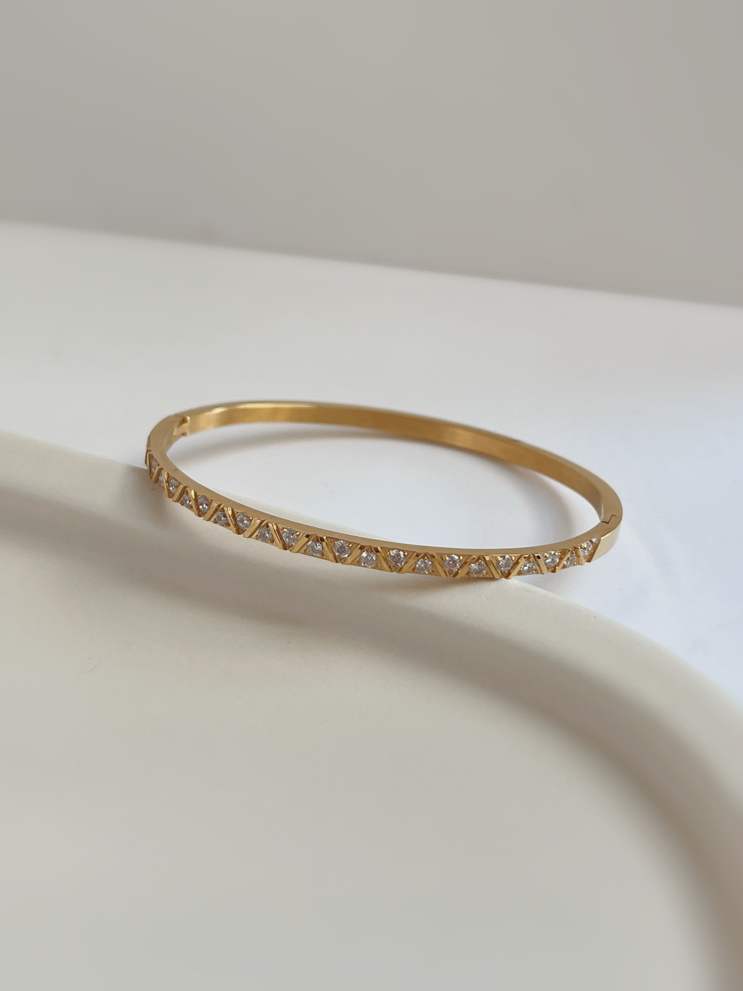 Detailed macro view of the Gia gold multi-stone bangle showing the geometric track of brilliant 5A cubic zirconia stones.
