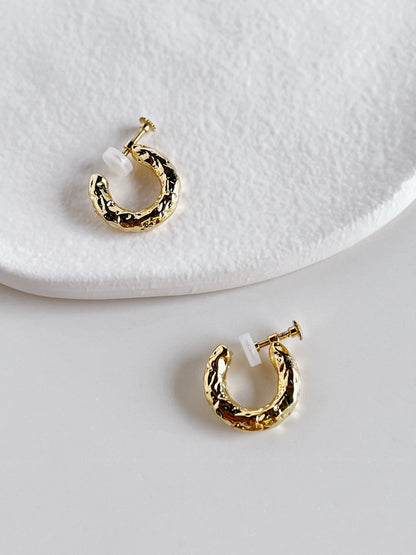 Flatlay studio photograph showing the 8mm outer diameter and 1.7mm band width of the Gigi clip-on earrings side-by-side on white plaster.
