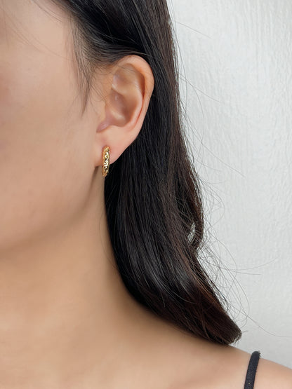 Close-up profile of a model wearing the Gigi 8mm clip-on huggie, demonstrating its snug fit around unpierced earlobes.