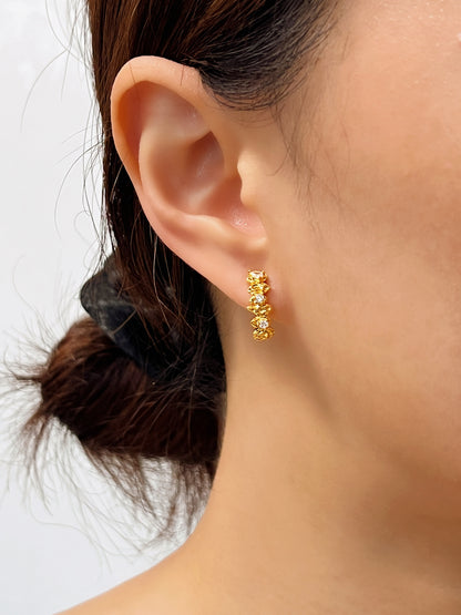 Front profile view of the Celeste gold textured ear climber clip-on earrings, demonstrating how the molten cosmic design contours smoothly along the non-pierced earlobe.