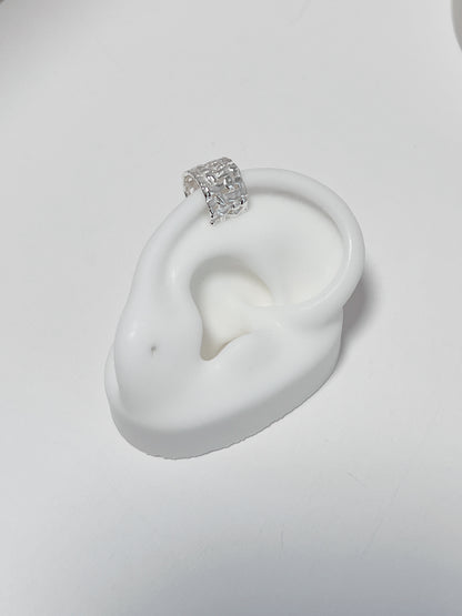 Natural light shot of the Carmela cuff on a white fake silicone ears showing the authentic, premium silver luster.
