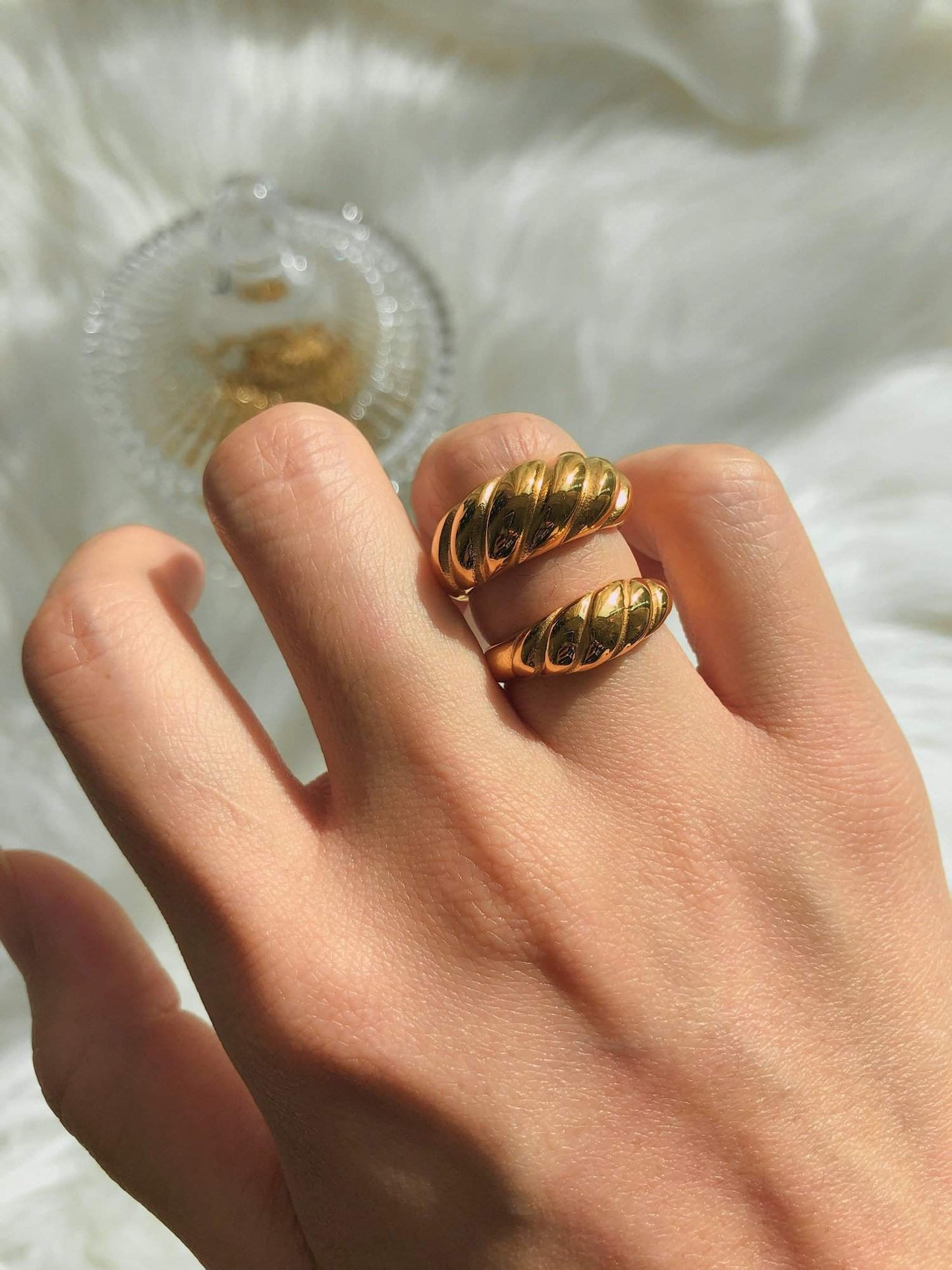 Hand model wearing thick and slim Valencia gold croissant ring on ring finger