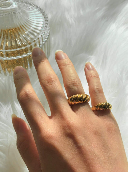 Close up of hand stacking thick and slim gold croissant rings