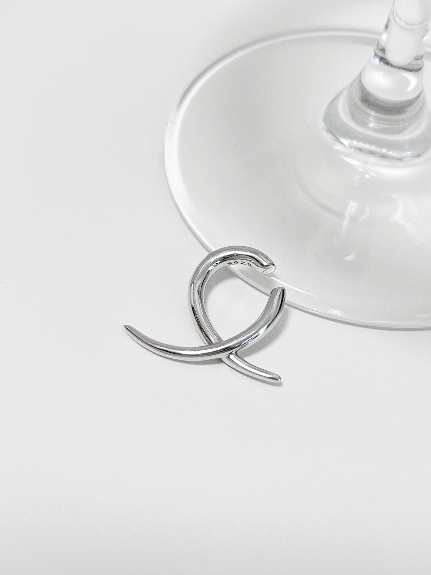 Close-up of silver Harley Geometric Ear Cuff showing the S925 hallmark and sharp "X" design.