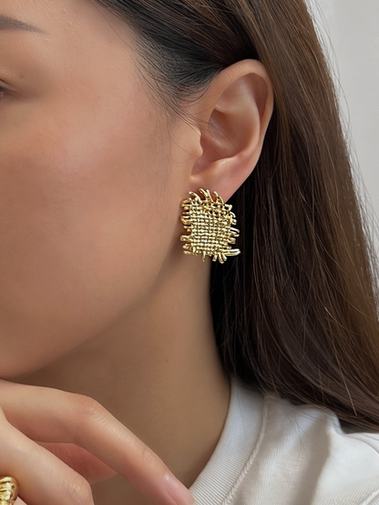 Close-up side profile of model wearing gold Hazel woven textured clip-on earring on unpierced ear