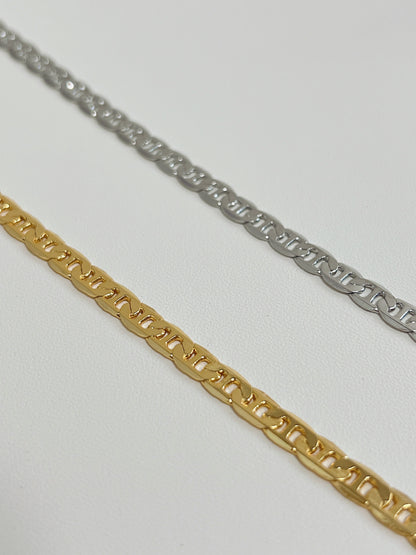 Close up perspective of the highly reflective flat-milled anchor links on an 18k gold plated mariner necklace